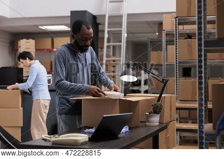 Employee Preparing Client Package Putting Bubble Wrap On Order For Protection During Shipping, While