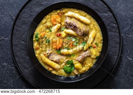 Gungo Peas, Pigeon Peas Soup With Dumplings And Beef In Black Bowl On Concrete Table, Jamaican Cuisi