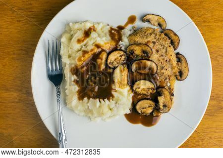 Baked Chicken Breast  Top With Mushroms And Gravy Served With Mashed Potatoes