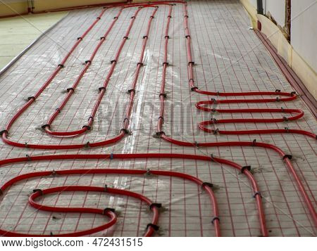 Underfloor Heating In Construction Of New Residential House. Pipefitter Installing System Of Heating