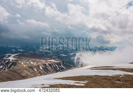 Awesome Top View Through Clouds To High Snowy Mountains. Scenic Landscape With Beautiful Snow Mounta