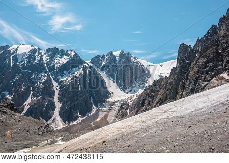 Scenic Mountain Landscape With Glacier Under Sharp Rocks In Sunlight. Awesome Landscape With Glacial