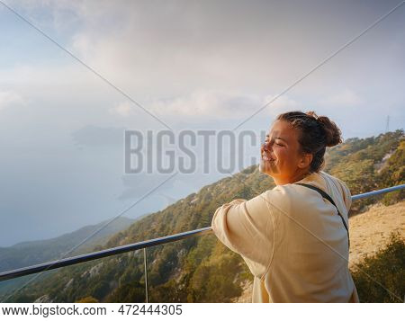 Woman Enjoys The View From The Viewpont Over Oludeniz, Turkey. Sunset, Clouds, Paragliders. Mount Ba