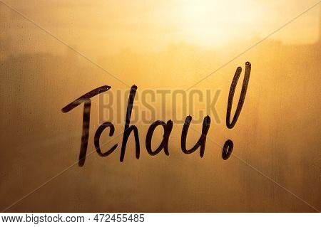 Handwritten Lettering Tchau In Portuguese Language Is Bye In English On Misted Glass On Sunset Orang