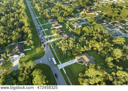 Aerial View Of American Yellow School Bus Picking Up Children At Sidewalk Bus Stop For Their Lessong