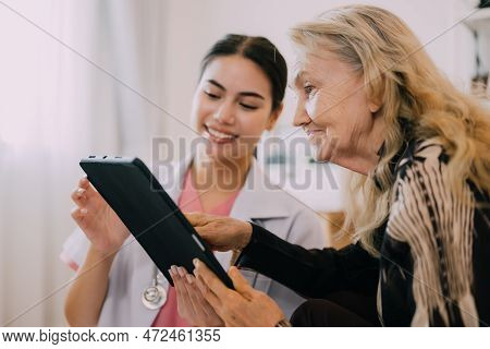 Professional Doctor Explaining Prescription To Senior Patient At Home Visit