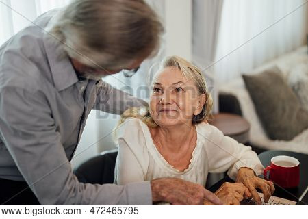 Healthy Grandfather And Grandmother Using Laptop For Entertainment And Shopping