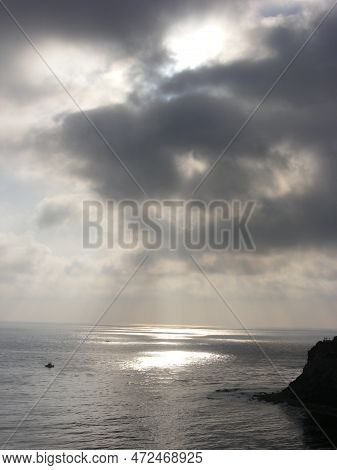 The Sun Creates A Golden Pool Of Light On The Ocean. Rays Of Light Break Through Cloud Cover. High Q