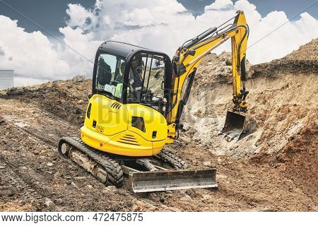 Mini Excavator At The Construction Site. Compact Construction Equipment For Earthworks. An Indispens