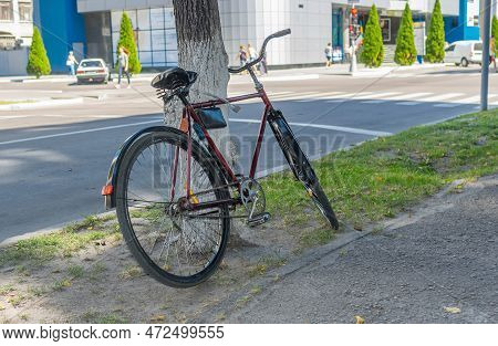 Lonely Old Bicycle Chained To Tree On A Street In Kremenchuk City, Ukraine