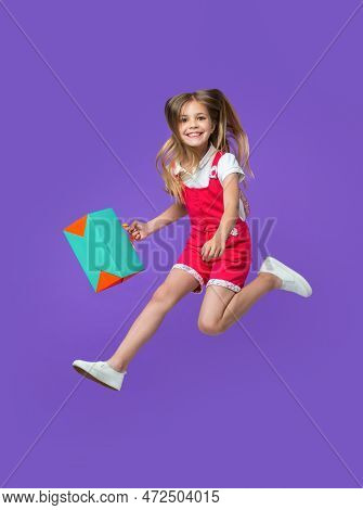 Cheerful Teen Girl Jumping After Shopping Isolated On Purple. Teen Girl Jumping After Shopping