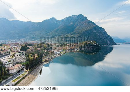 Sunny Aerial Cityscape Of Lecco Town On Spring Day. Picturesque Waterfront Of Lecco Town Located Bet