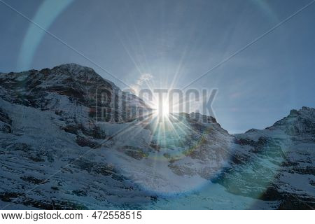Eigergletscher, Canton Bern, Switzerland, February 11, 2023 Sun Is Rising Behind A Summit Of The Sno