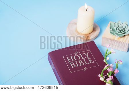 Christian Holy Bible With сandle On Blue Background, Flat Lay, Top View