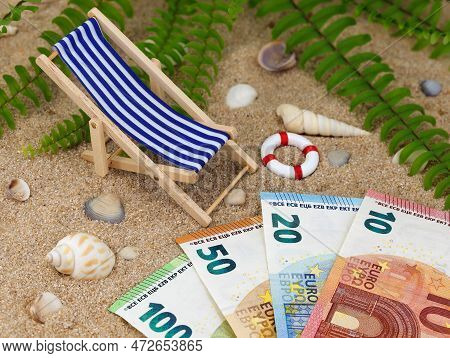 Deck Chair With Euro Banknotes In The Sand With Sea Shells And Tropical Background, Concept Of Savin