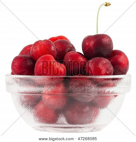 Frutas de cerezas en un recipiente de vidrio aislado sobre fondo blanco