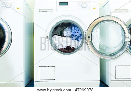 laundry with washing machines side by side, fresh laundry lies in the drum