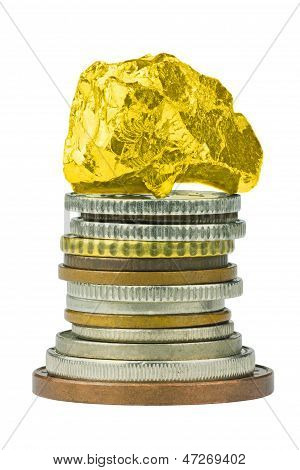 Pila de moneda con pepita de oro en la parte superior