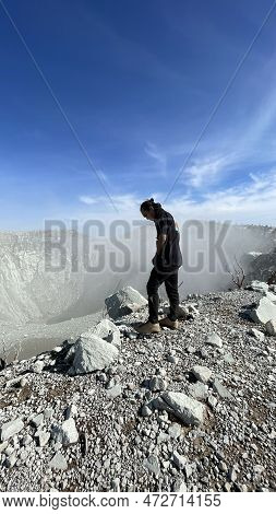 Asian Man Standing On Top Of A Nearby Mountain Looking At Mount Sindoro. West Java, Indonesia, March