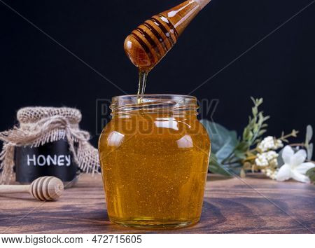 Honey Spoon Coming Out Of The Jar Full Of Honey. Honey Contains Many Nutrients, Antioxidants, Improv