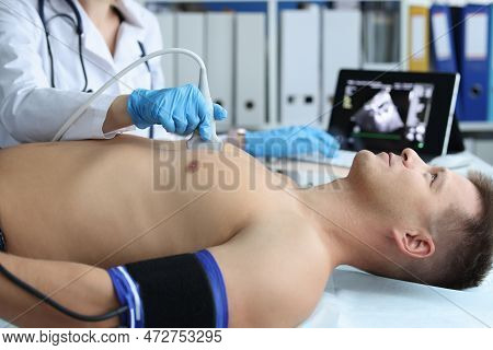 Doctor Places Ultrasound Probe On Chest Of Male Patient. Medical Examination Of The Work Of Heart An