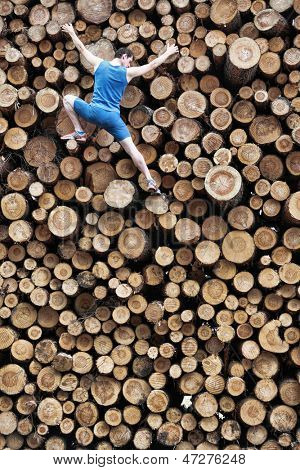 Monter le grimpeur en descendant le gros tas de billes de bois coupées
