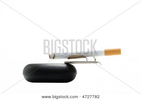 Cigarette On Ashtray Over White