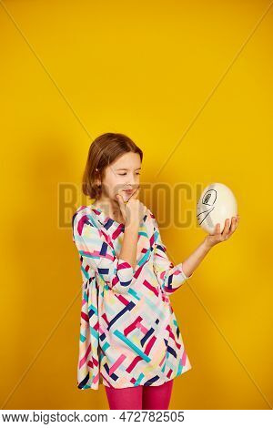 Serious Teenager Girl Holding Ostrich Egg With Funny Face