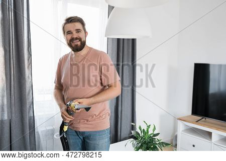 Man Holding Modern Washing Vacuum Cleaner And Cleaning Dirty Sofa With Professionally Detergent. Pro