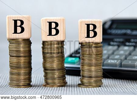 Bbb (better Business Bureau) Acronym On Wooden Cubes On The Background Of Coins And Calculator. Busi