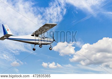 Single Engine Ultralight Plane Flying In The Blue Sky With White Clouds