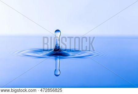 Water Drop. Transparent Water Drop With Circular Waves. Slightly Blurred Golden Yellow Splattered Wa