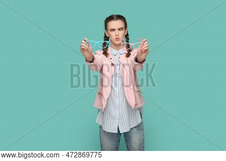 Portrait Of Funny Crosseyed Teenager Girl With Braids Wearing Pink Jacket Holding Two Eyewear, Havin