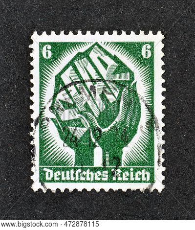 Cancelled Postage Stamp Printed By German, Reich, That Shows Two Hands Holding A Piece Of Coal With 