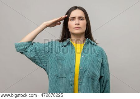 Yes Sir. Serious Smart Young Woman Giving Salute, Listening Carefully To Order, Looking With Respons