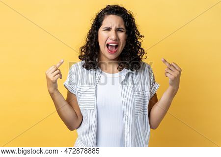 Portrait Of Woman With Dark Wavy Hair Rejecting Communication, Showing Middle Fingers To Express Dis