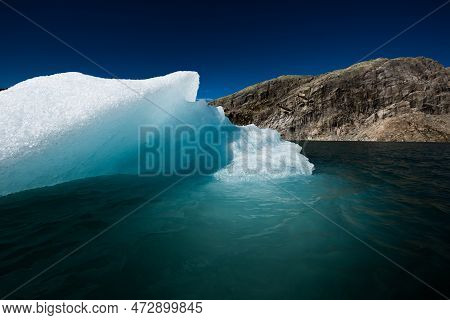 Chunk Of Glacier Ice Lit By Rising Sun Folgefonna Glacier Mosevatnet Lake, Norway