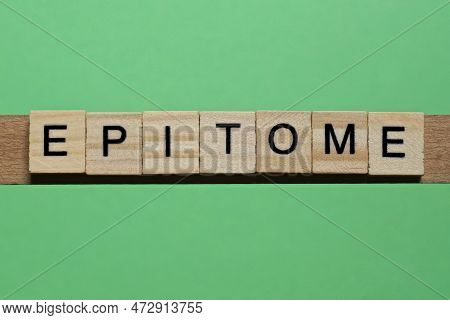 Word Epitome Made Of Small Gray Wooden Letters On A Green Paper Background