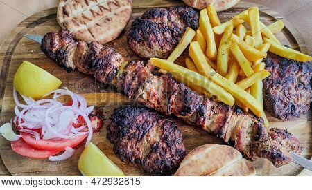 Greek Kontosouvli Large Souvlaki Made By Fresh Meat Grilled On Fire And Served With French Fries.