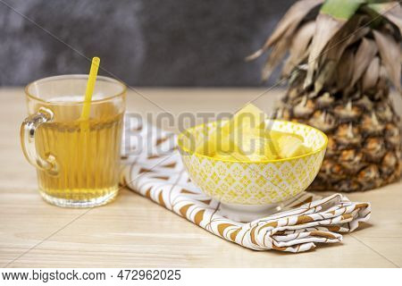 Yellow Bowl Full Of Ripe Pineapple Chunks, Half A Pineapple To Be Cleaned And A Crystal Glass With P