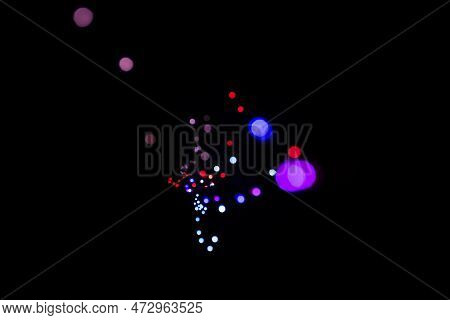 Bokeh Of Small Colored Lights In The Dark In The Shape Of An Enneagon Due To The Diaphragm Of The Le