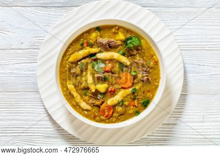 Gungo Peas, Pigeon Peas Soup With Dumplings , Vegetables And Beef In White Bowl On White Wood Table,