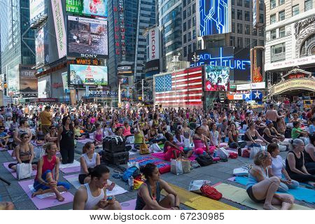 Thousands of New Yorkers are make the first day of summer by practicing yoga in Times Square