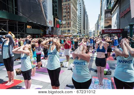 Thousands of New Yorkers are make the first day of summer by practicing yoga in Times Square