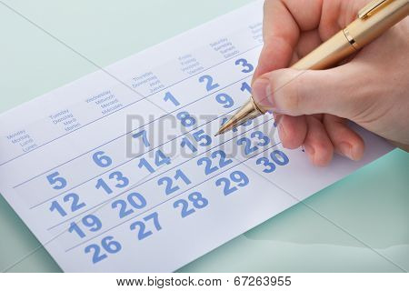 Hand Marking Date 15 On Calendar