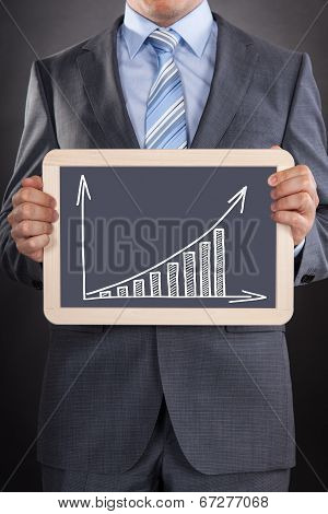 Businessman Showing Bargraph Drawn On Slate