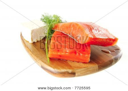 Rose saumon sur une plaque en bois avec du fromage