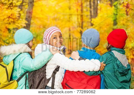 Back of kids with rucksacks standing in row close