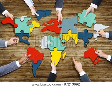 Business People Forming World Map with Puzzle Pieces