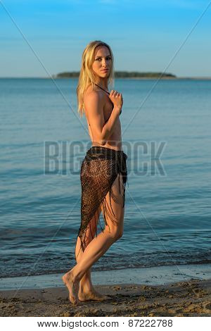 young woman in black bikini posing on a beach